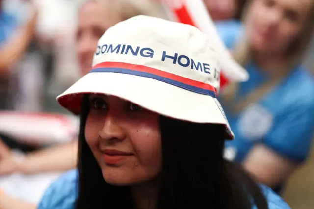 A fan sits at Box Park in her 'It's coming Home' bucket hat.