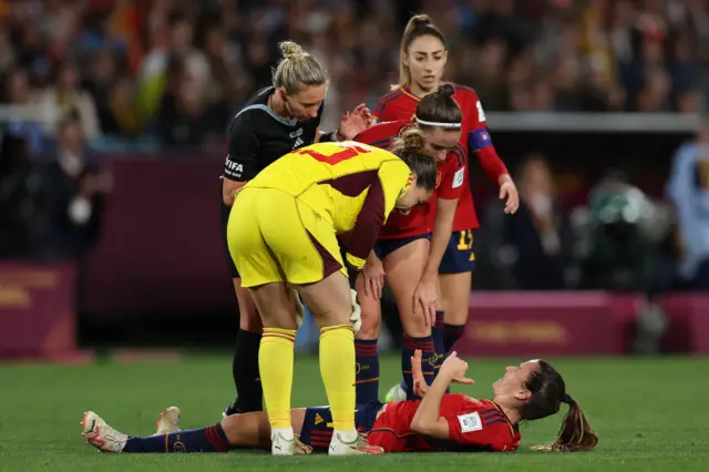 Codina lies on the floor as her teammates stand over her.