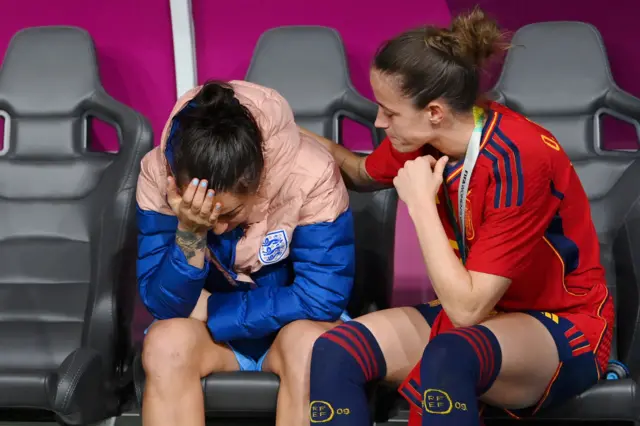 Lucy Bronze is consoled by Ona Batlle at full time on the England bench.