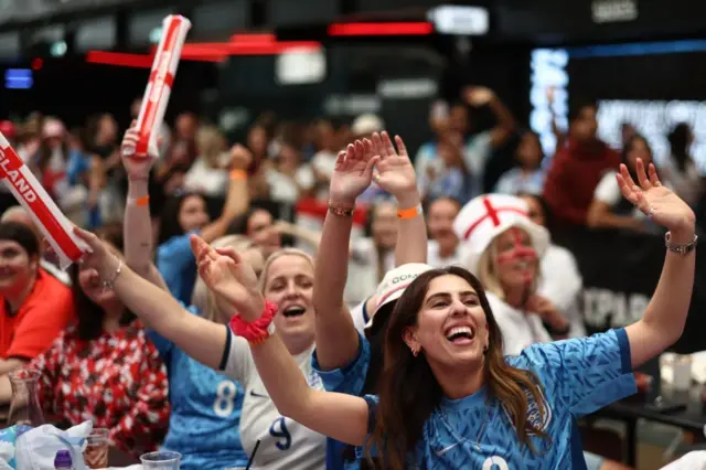 Fans sing songs at Box Park in their England gear.