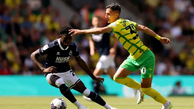 Dimitris Giannoulis of Norwich City runs with the ball whilst under pressure from Romain Esse of Millwall