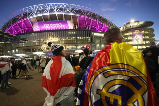 Fans with an England flag and Real Madrid Spanish flag arrive at the stadium.