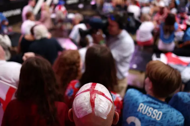 A fan whose head is painted with the England flag waits for the start of a live broadcast of the Women's World Cup final football match between Spain and England, at Boxpark