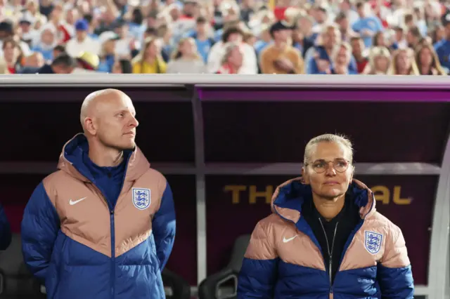 Wiegman and Veurink stand in the England dugout.