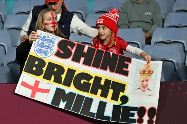 A banner reading 'shine bright millie' with a picture of the England captain.