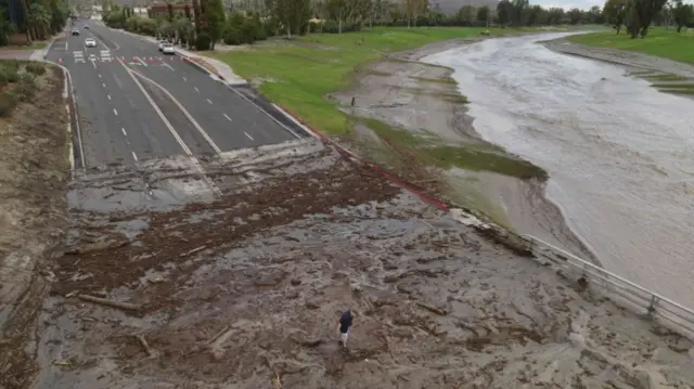 An aerial image shows a man surveying debris following heavy rains from Tropical Storm Hilary, at Thunderbird Country Club in Rancho Mirage, California