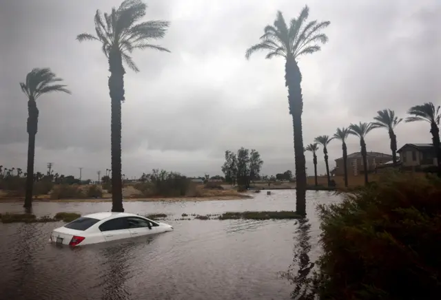 A car is partially submerged in floodwaters as Tropical Storm Hilary moves through the area on August 20, 2023 in Cathedral City, California.