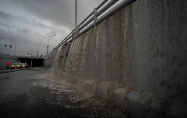 Water falls at the entrance of a tunnel as Tropical Storm Hilary hits Baja California state in Mexico