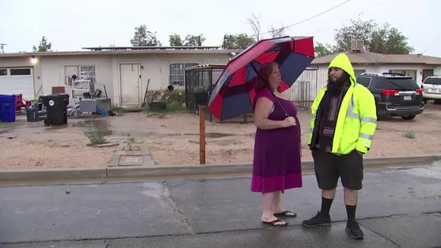 Juan and his mother stand outside their house