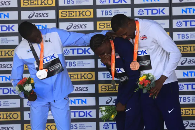 Silver medallist Letsile Tebogo of Botswana, champion Noah Lyles of the US and bronze medal winner Zharnel Hughes of Great Britain (L-R) at the medal ceremony for the men's 100m