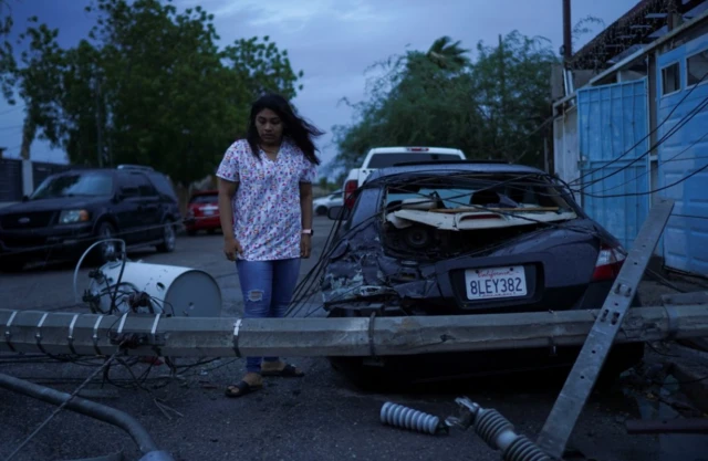 A light pole hit Laura Elizalde Reyes's car on Sunday as Tropical Storm Hilary hits Baja California state, in Mexicali, Mexico