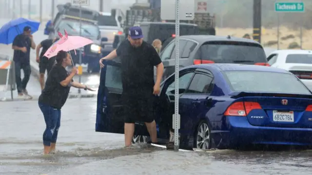 Motorists deal with a flooded road and stuck vehichles during heavy rains from Tropical Storm Hilary in Palm Springs, California, on August 20, 2023