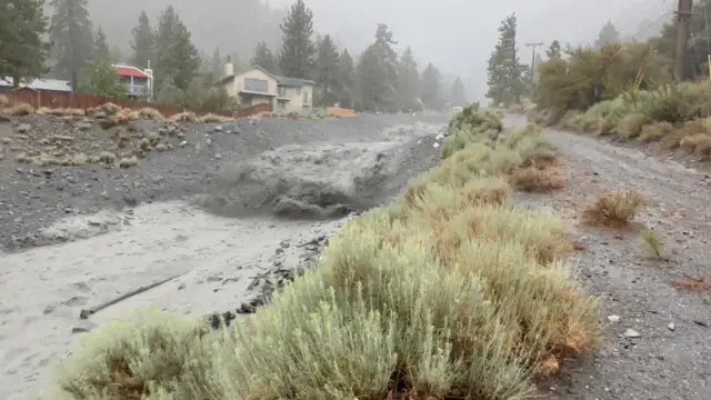 A floodwater river is grey with gravel