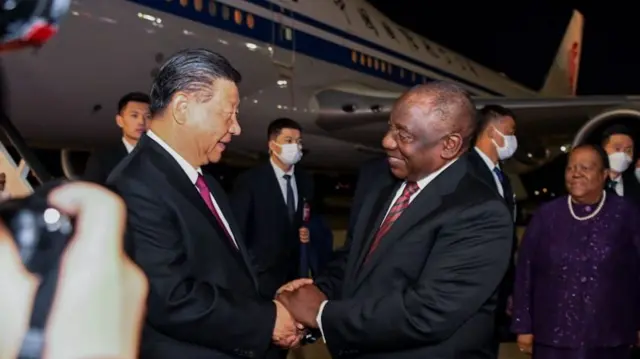 Chinese President Xi Jinping (L) is welcomed by South African President Cyril Ramaphosa on arrival in Johannesburg on 22 August 2023