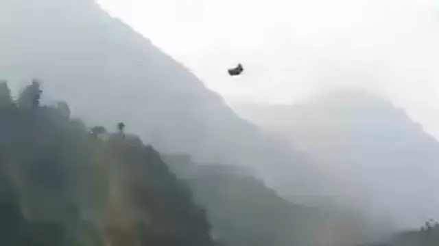 A cable car dangling over mountains