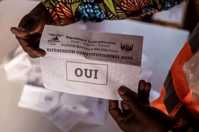 A employee of the national agency for elections shows a "yes" ballot as votes are counted following a referendum on a new constitution that would allow the president to seek a third term, at Mandaba school in Boyrabe district, in Bangui, on July 30, 2023.