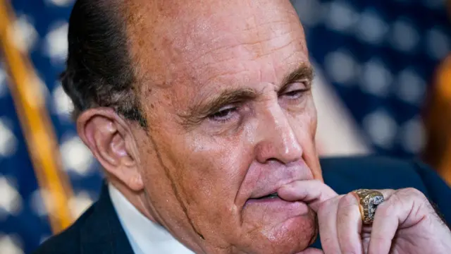 Trump's former personal lawyer Rudy Giuliani is pictured with sweat dripping down his face in 2020