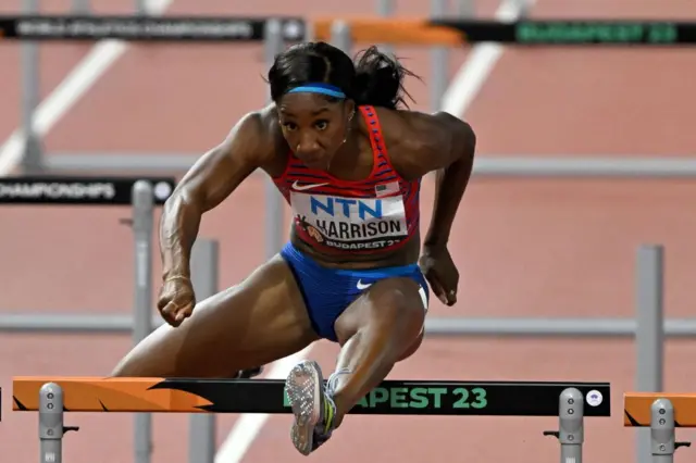 Kendra Harrison jumps over a hurdle