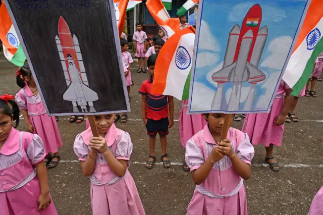 Students wave India's national flag as they hold posters in support of the Chandrayaan-3 spacecraft in Mumbai on August 22, 2023