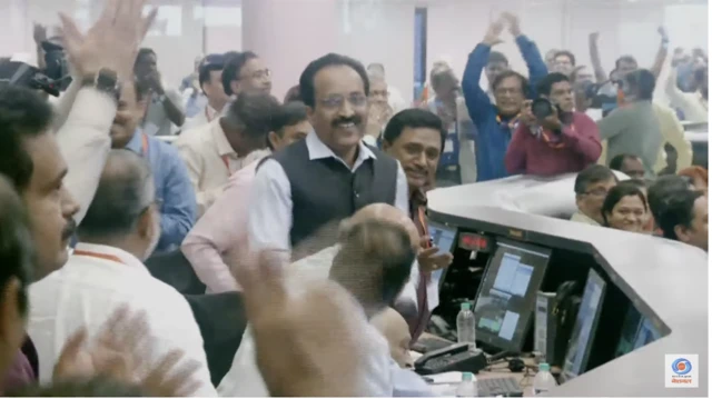 People celebrate in the control room