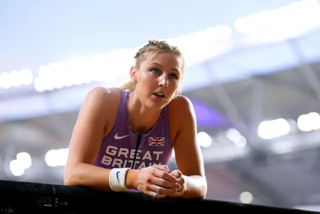 Molly Caudery leans on the advertising boards around the side of the tracks.