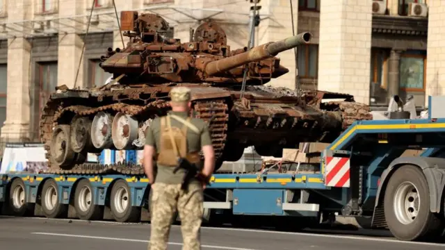 A soldier looks on as Russian armored military vehicles that were seized by the Ukrainian army amid the Russian invasion are put in place along Khreshchatyk Street in Kyiv