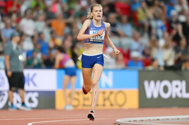 Megan Keith running on track with blood running down her left leg