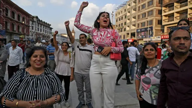 A woman yells in jubilation surrounded by a crowd