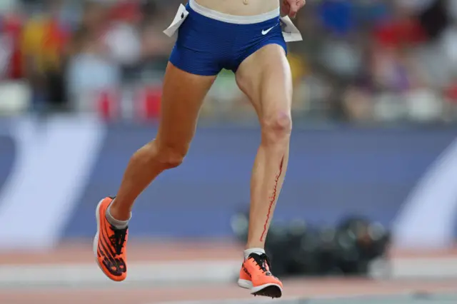 Megan Keith running on track with blood running down her left leg