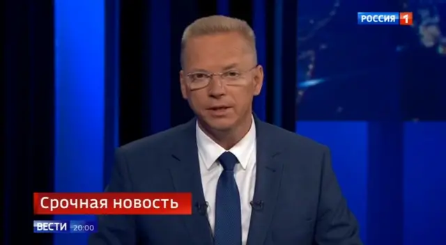 A newsreader in a suit on Russian state-run news channel Rossiya 1