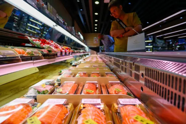 A customer surveys sushi and sashimi at a supermarket that sells certain Japanese seafood affected by the city's import ban, in Hong Kong, China, 23 August 2023.