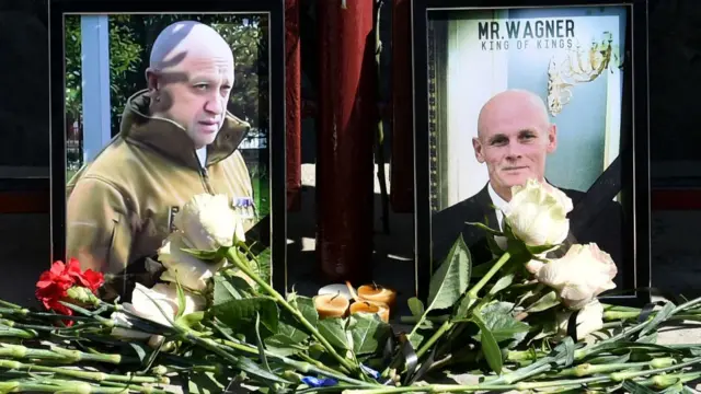 Portraits of Yevgeny Prigozhin (left) and Dmitry Utkin are seen at the makeshift memorial in front of the Wagner office in Novosibirsk