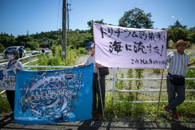 rotesters hold a banner reading "No dumping of radioactive water into the ocean" during a rally in Okuma-machi of Fukushima Prefecture