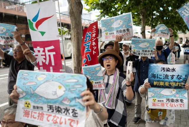 Protesters demonstrate in Tokyo holding signs