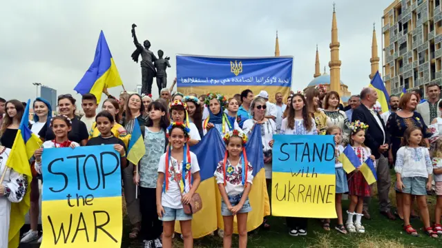 A crowd of people holding pro-Ukrainian flags and banners