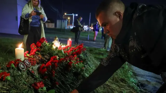 A man puts a patch at a makeshift memorial near former PMC Wagner Centre in Saint Petersburg, Russia August 24, 2023.