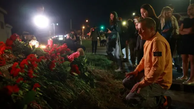 People pay tribute to Yevgeny Prigozhin at the makeshift memorial in front of the "PMC Wagner Centre" in Saint Petersburg,