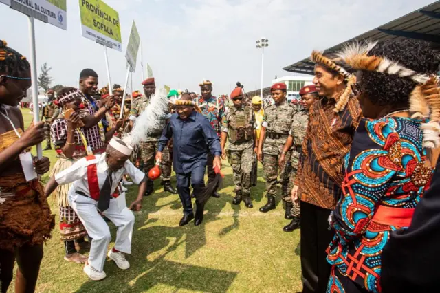 Mozambican and Indonesian presidents dancing in a crowd of people.