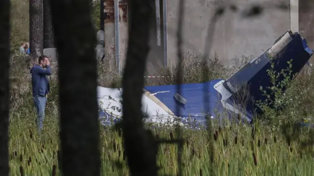 A Russian law enforcement official inspects the wreckage of a crashed plane