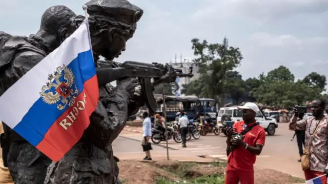 A Russian flag with the emblem of Russia on hang on the monument of the Russian instructors in Bangui, on March 22, 2023 during a march in support of Russia presence in the Central African Republic