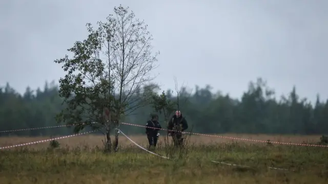 Police officers cordon off an area in a field near the site of crash of a private jet linked to Prigozhin