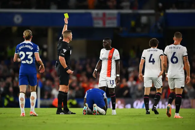 Nakamba is shown a yellow card by the ref for a foul on Jackson.