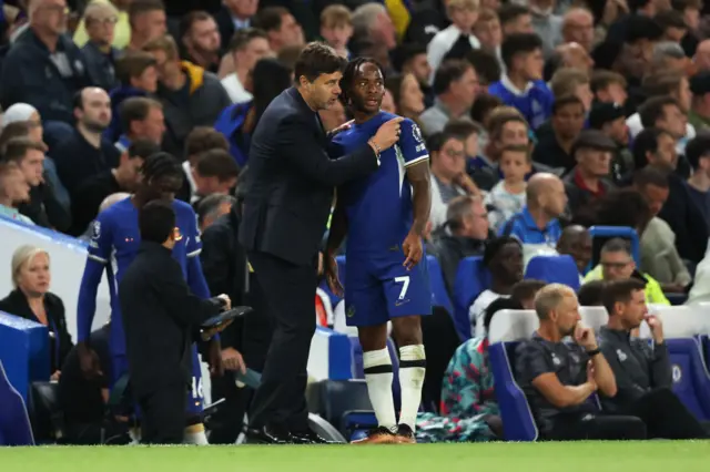 Sterling is given instructions by Pochettino on the sidelines.