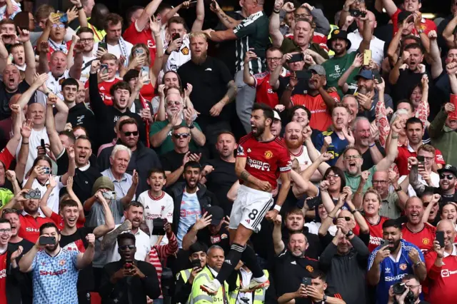 Bruno Fernandes jumps and first pumps into the air after scoring their third.