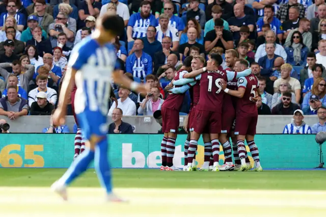 West Ham celebrate their goal with Brighton's Mitoma trudging back to half way in the foreground.