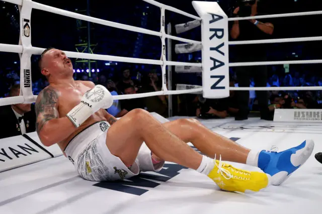 Oleksandr Usyk sits on the canvas