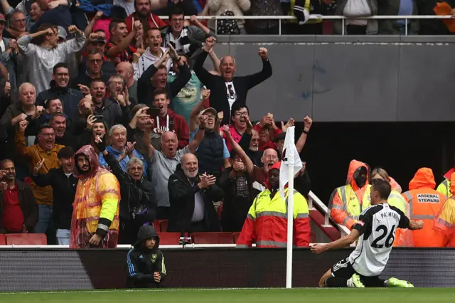 Palhinha knee slides at the corner in front of the travelling Fulham fans.