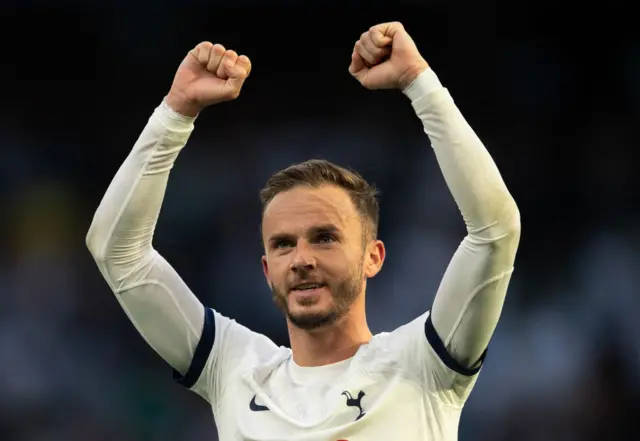 James Maddison holds his arms aloft in the air.