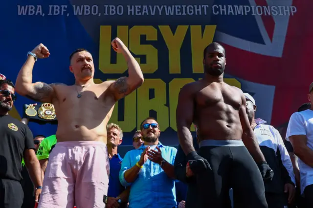 Oleksandr Usyk holds up both arms as he stands next to Daniel Dubois