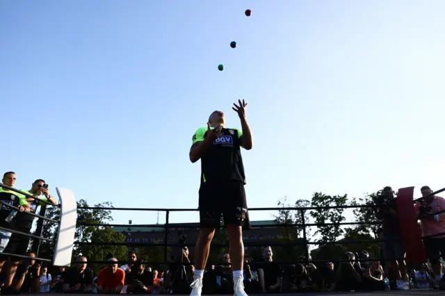 Oleksandr Usyk juggles in a boxing ring